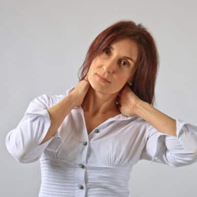 average age woman holding neck in pain