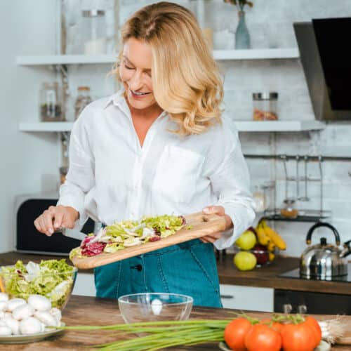 woman chopping up healthy foods in kitchen