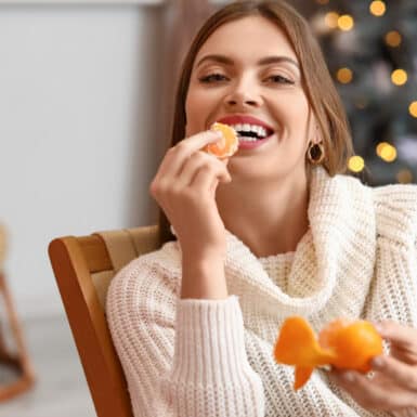 woman happily eating anti inflammatory citrus food during winter