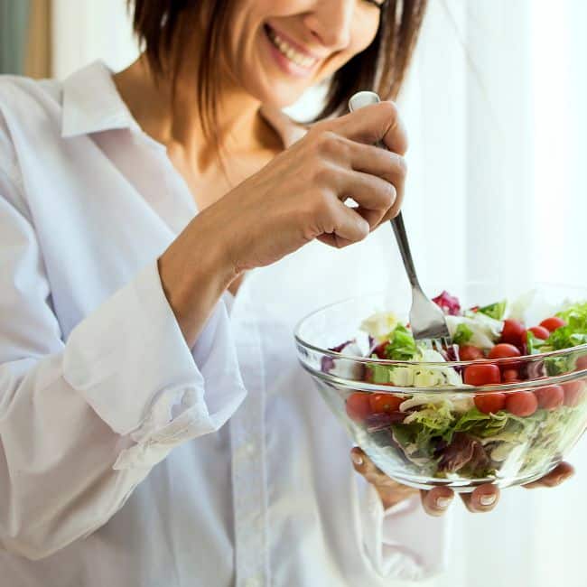woman looking happy eating healthy food for ways to lose weight without dieting