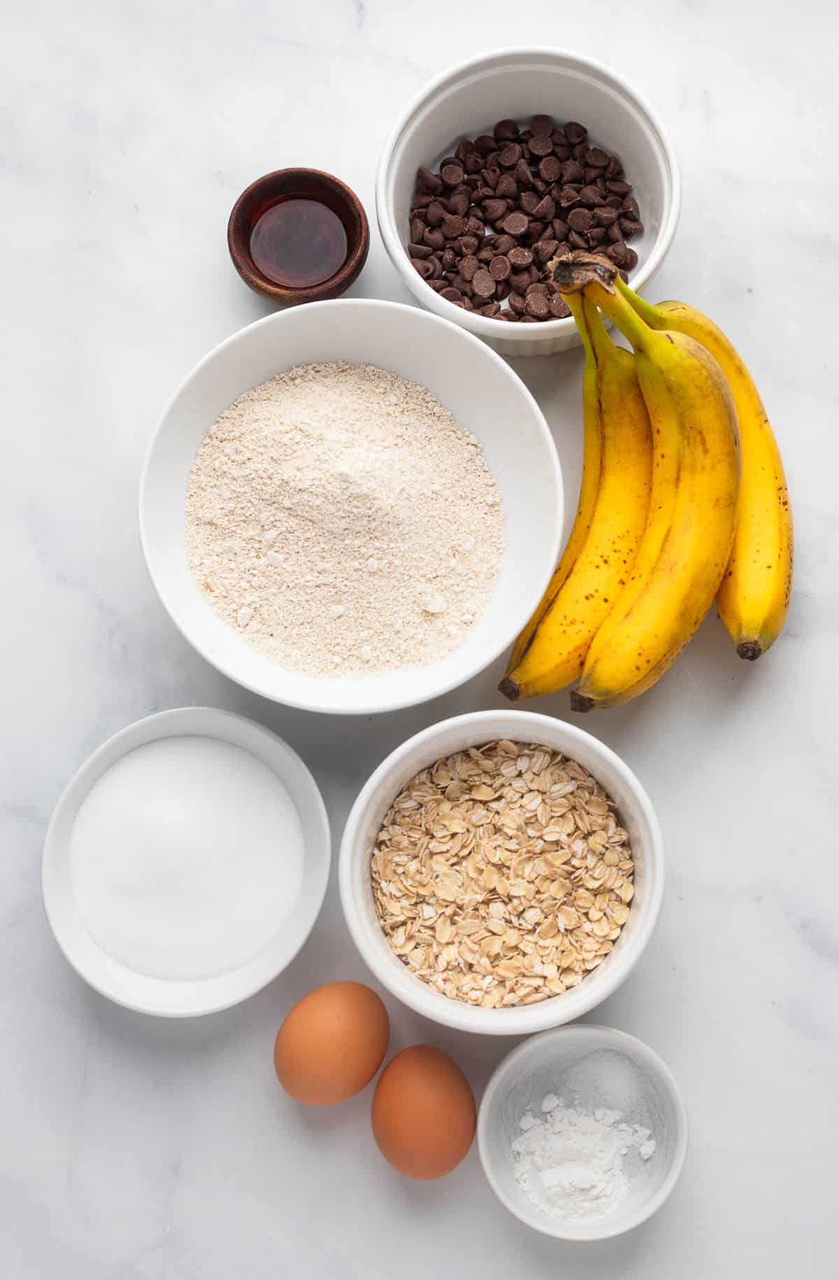top view of raw ingredients laid out on counter to make healthy oat flour banana muffins