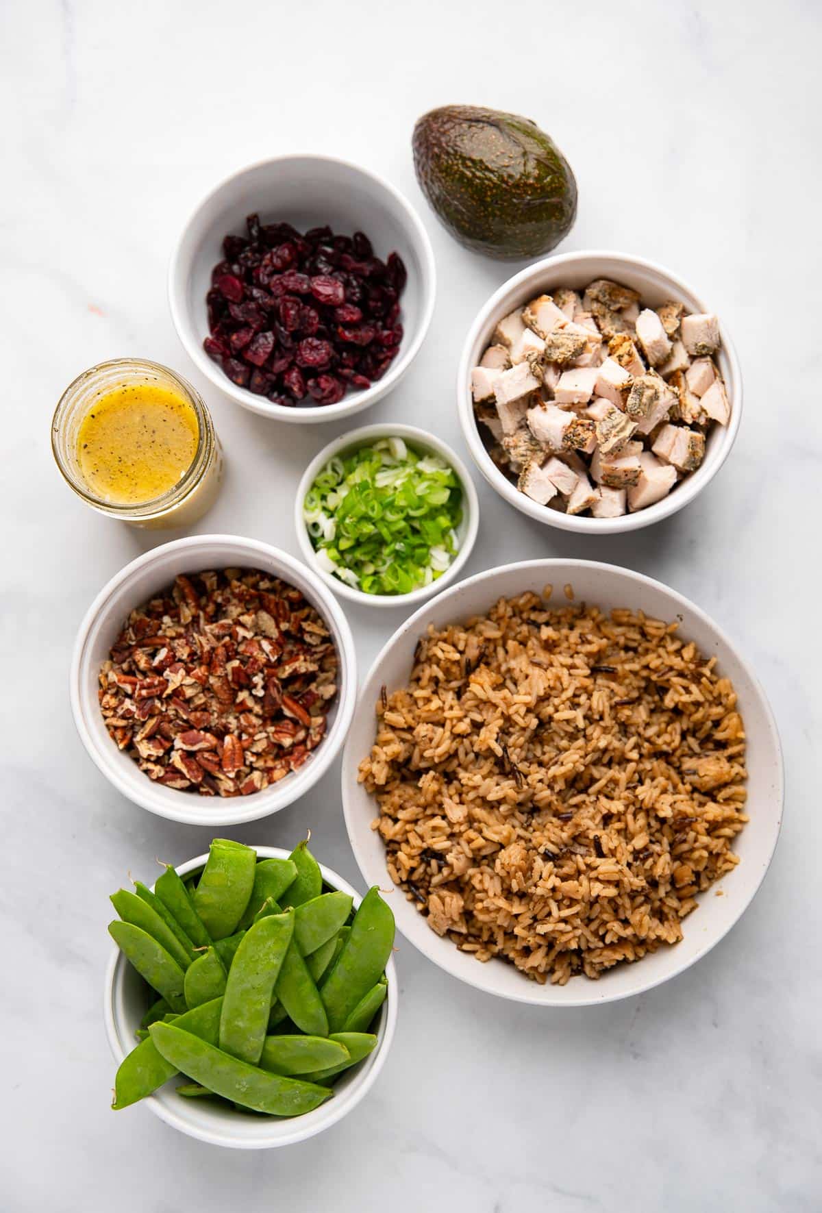 raw ingredients to make wild rice salad with chicken on white counter backdrop