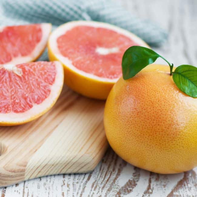 best foods that lower cholesterol whole and sliced grapefruit on wooden board