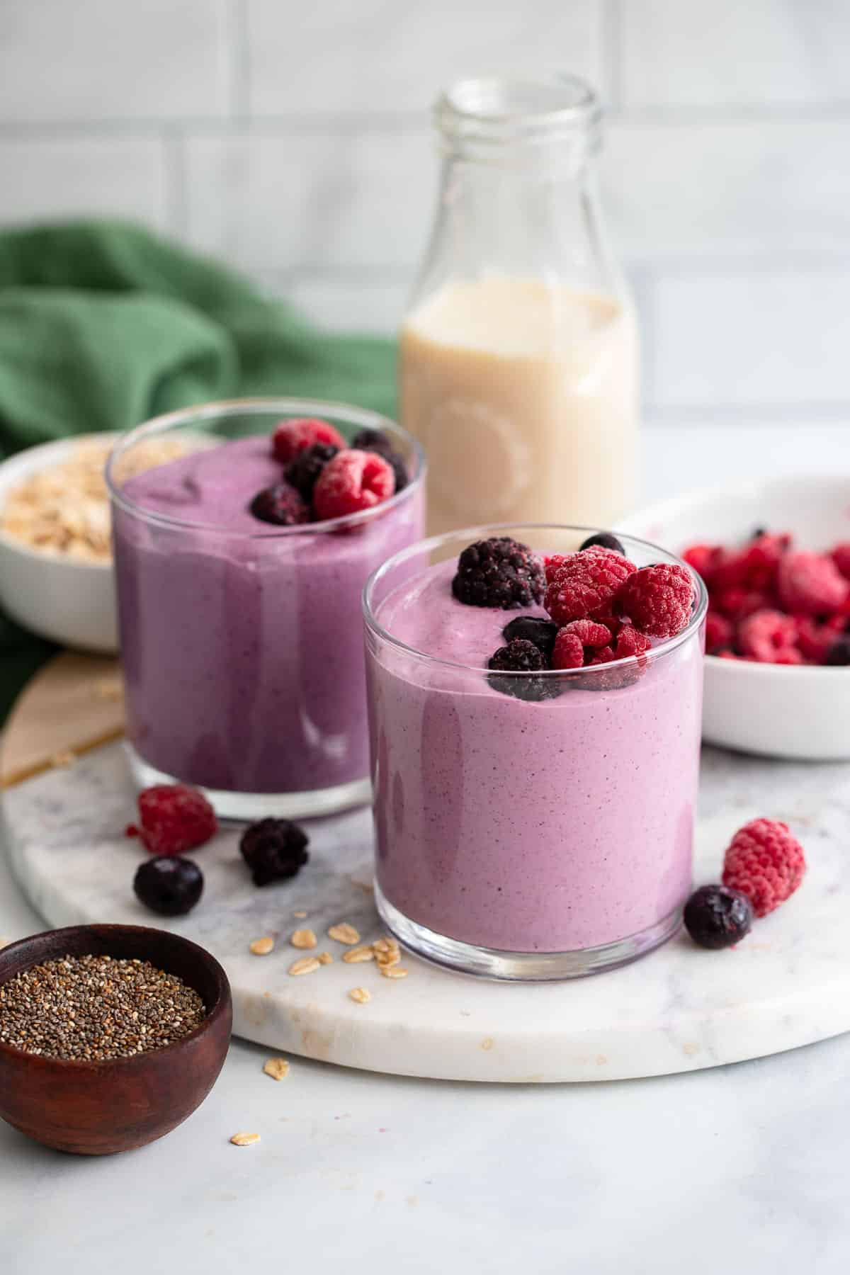 two single servings of healthy mixed berry smoothie with raspberries and blackberries
