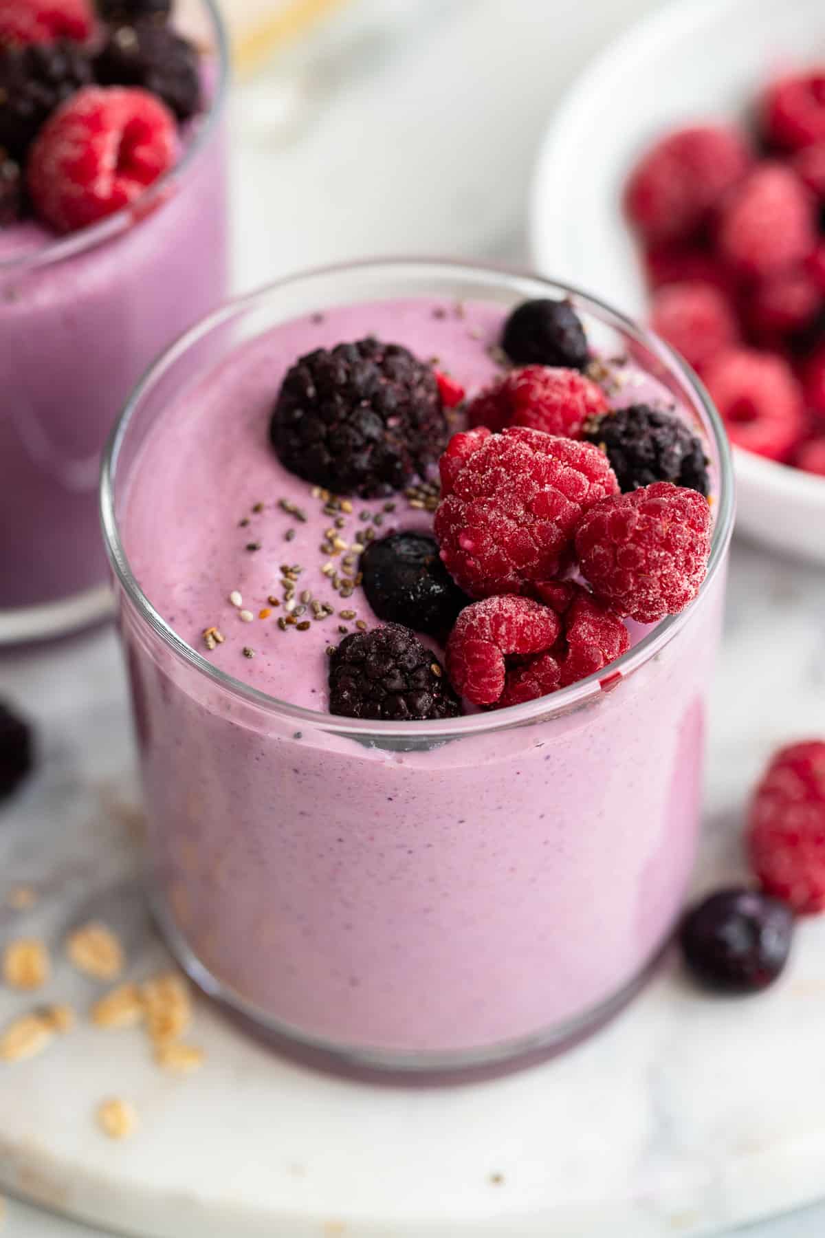 close up shot of mixed berry smoothie with berry toppings