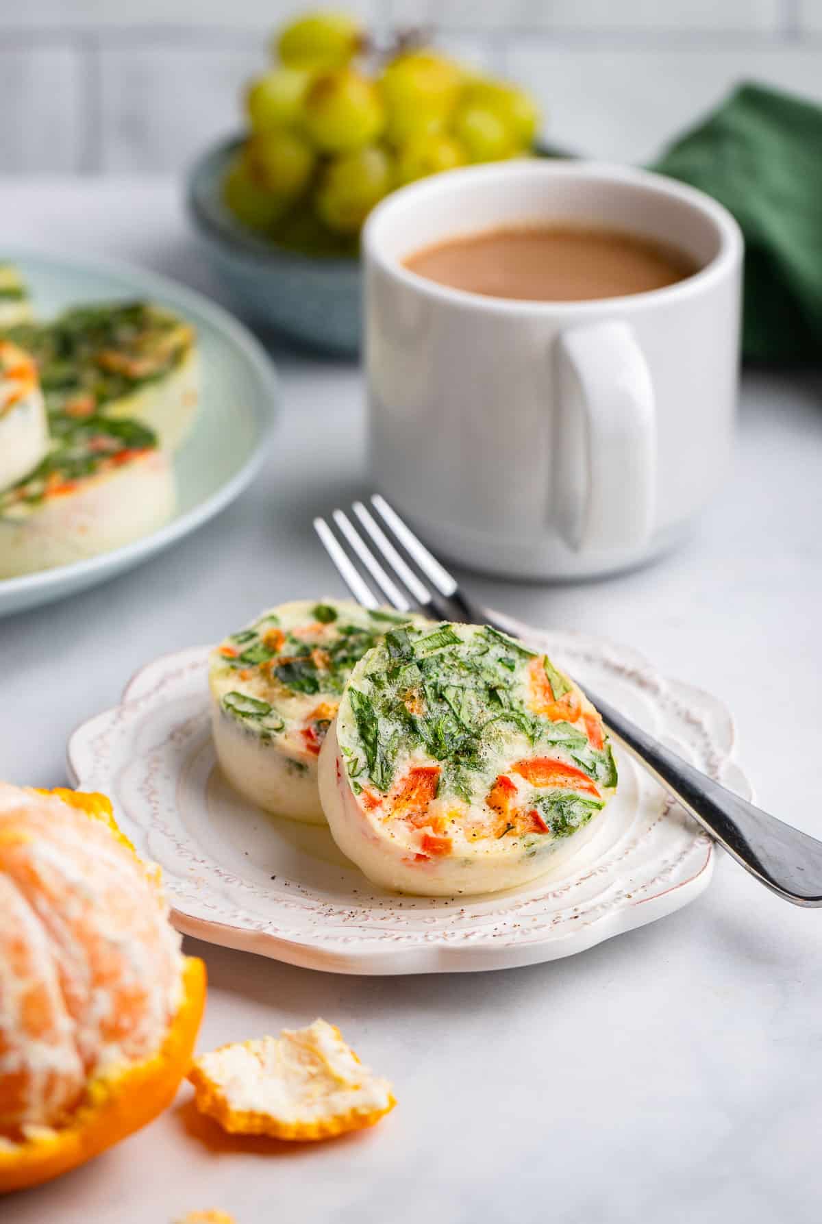 two prepared healthy egg white bites on place next to mug of coffee