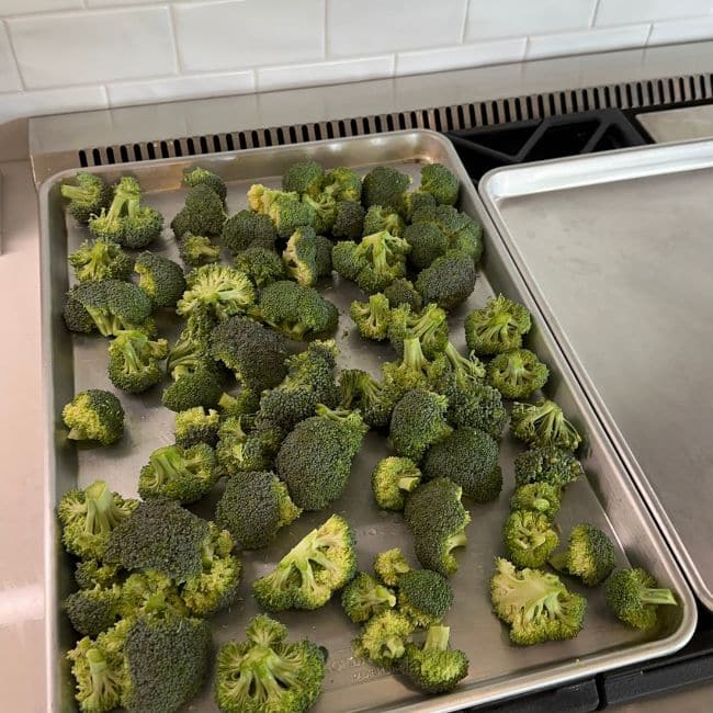 extra large baking sheet with broccoli on kitchen stove