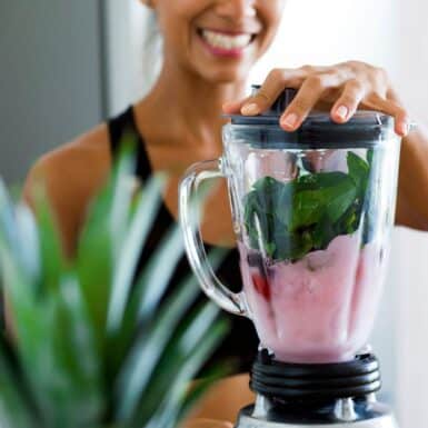 woman preparing healthy smoothie recipe for weight loss in blender