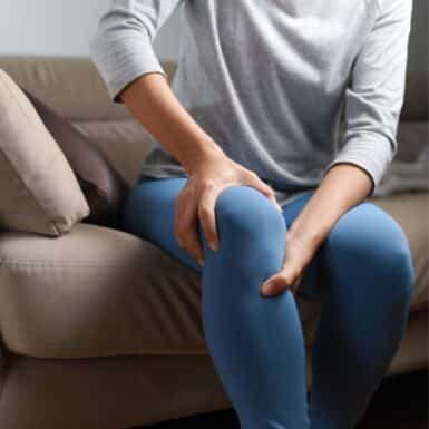 woman holding knee with menopause joint pain
