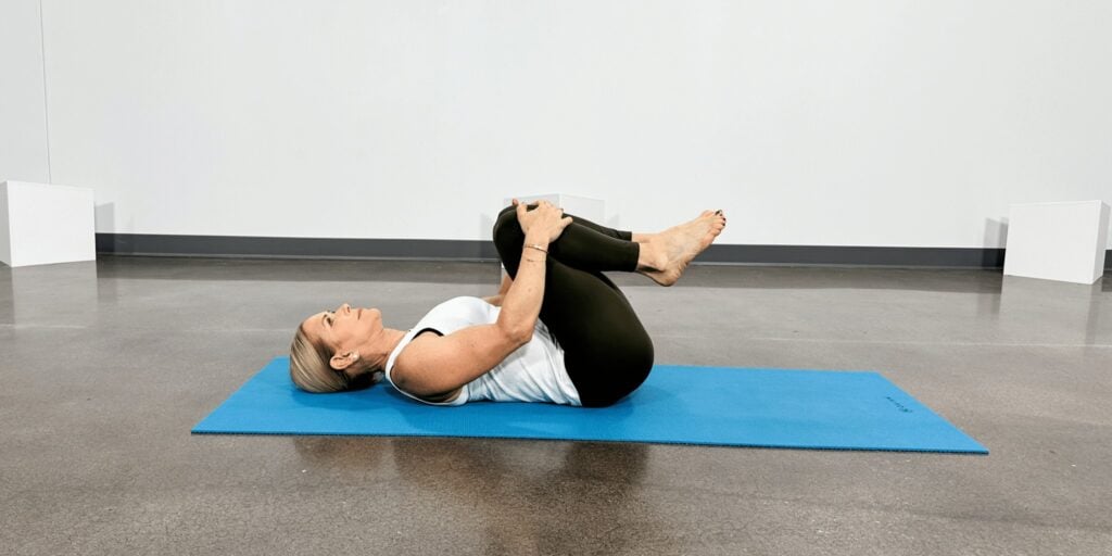 woman doing yoga poses for back pain, knee to chest pose