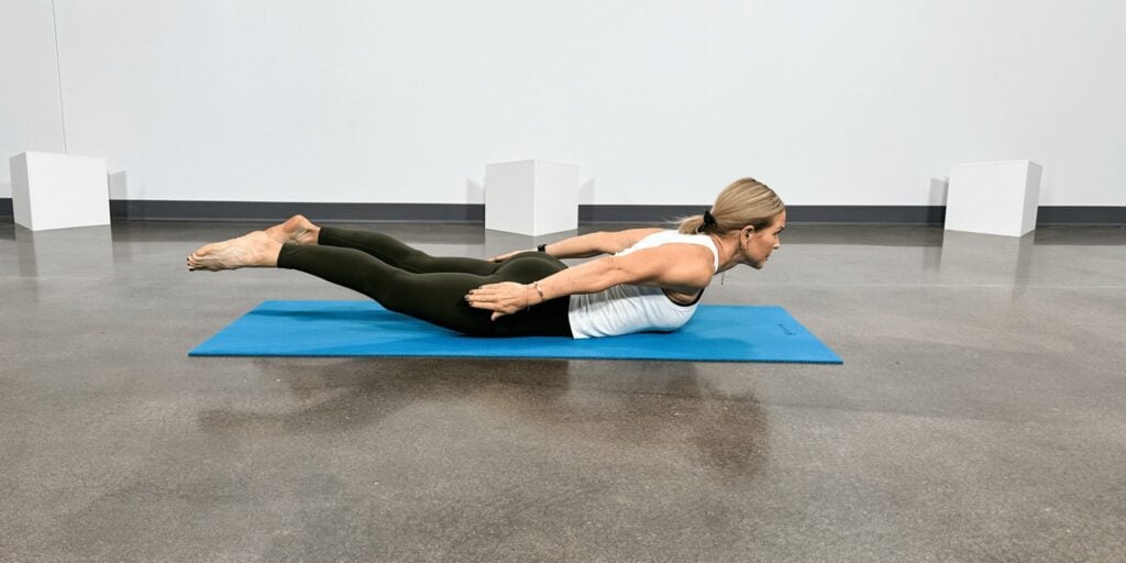 woman doing yoga poses for back pain, swimmer pose