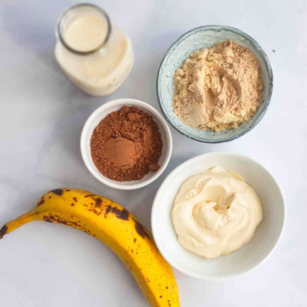 Raw ingredients for a chocolate banana smoothie recipe on the counter