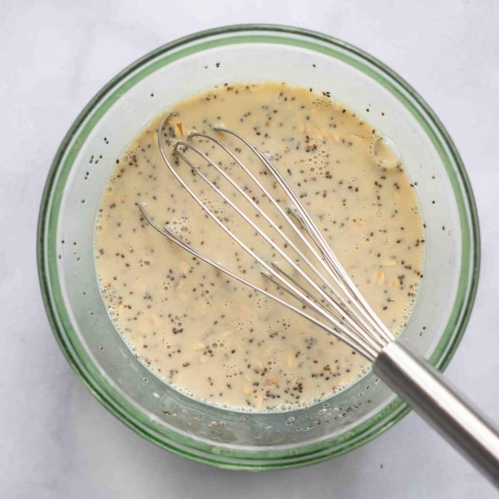 mixing vanilla overnight oats in glass bowl with whisk