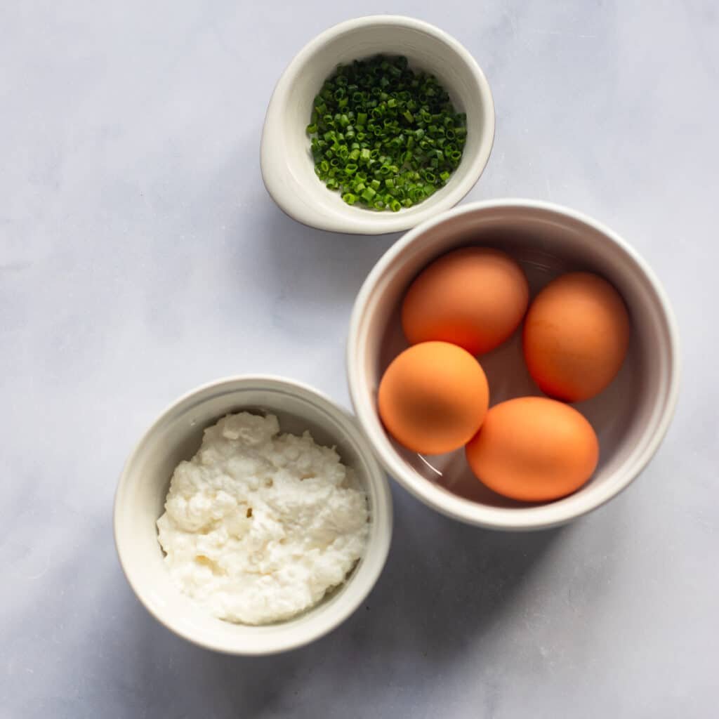 Raw ingredients for making cheesy scrambled eggs