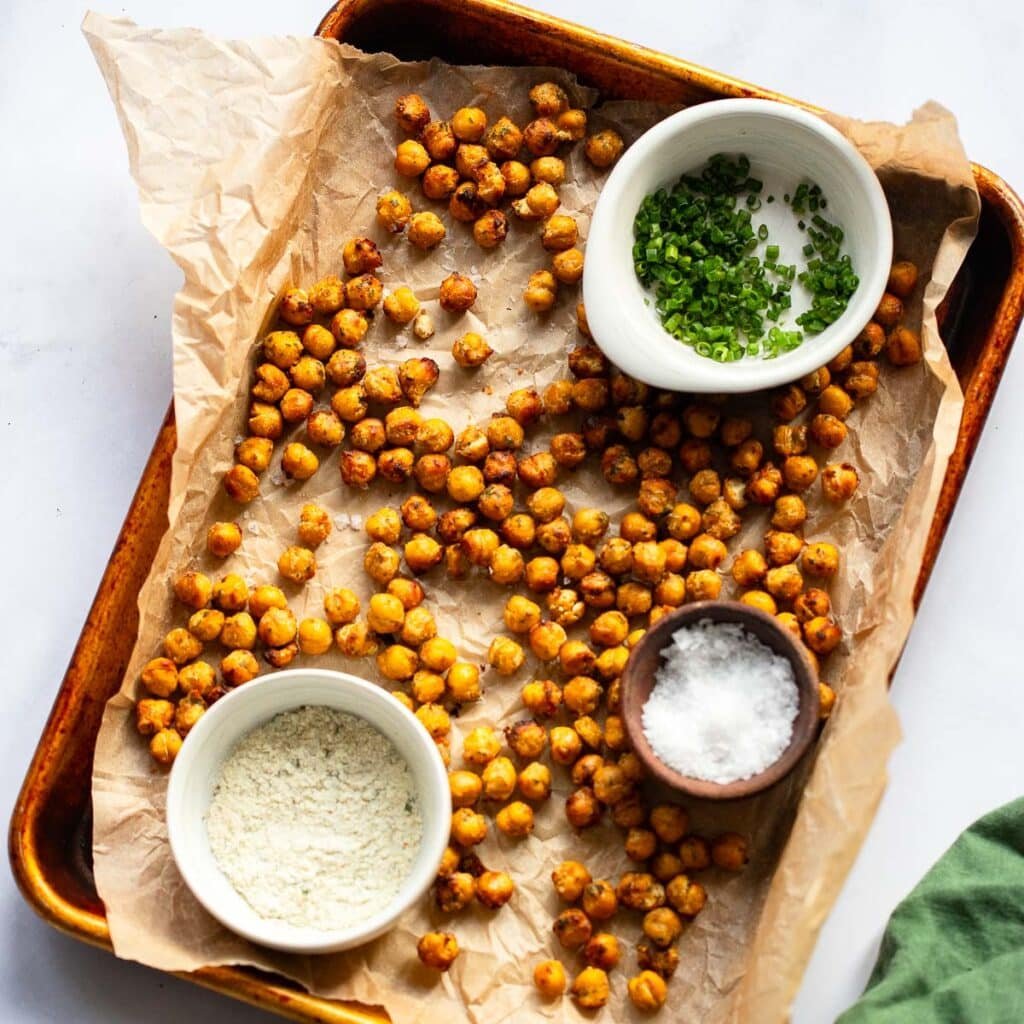 crispy ranch roasted chickpeas on baking sheet with garnish in bowls