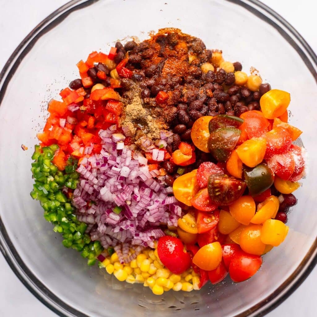 ingredients for dense bean salad in glass bowl