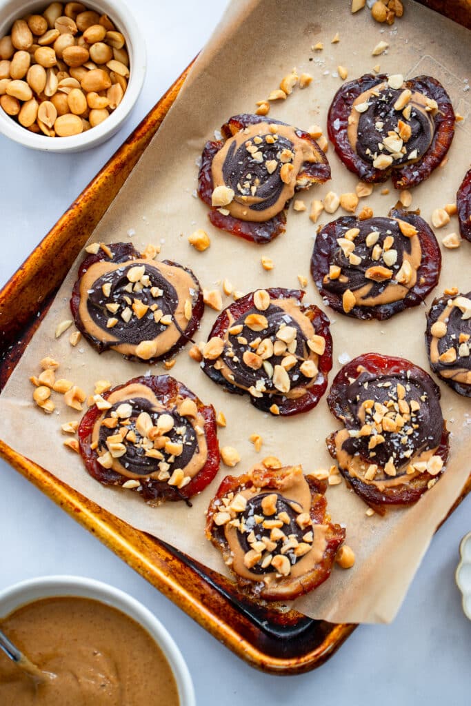 finished healthy date snickers topped with peanuts and salt on baking sheet