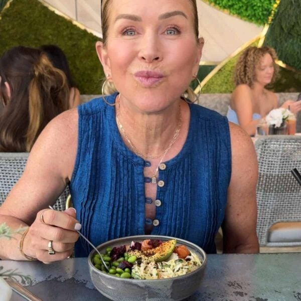 Woman enjoying a colorful bowl of healthy food.
