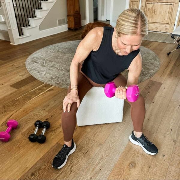 Woman over 50 strength training with dumbbells to build muscle after menopause