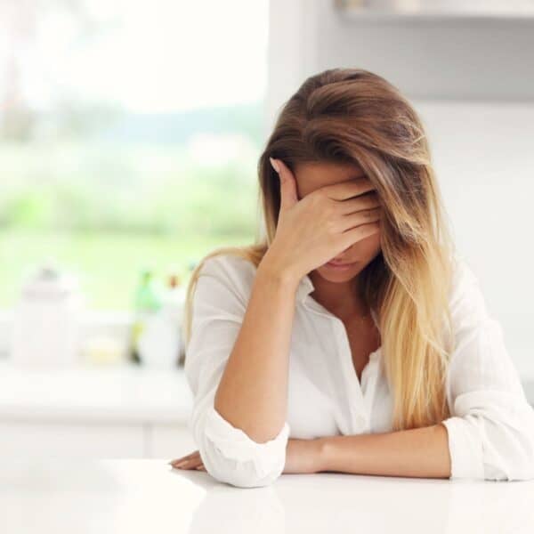 woman with menopause headache with hand over face