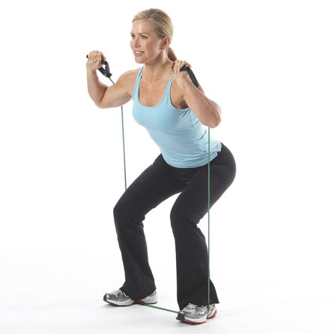 Woman performing resistance band squats workout.