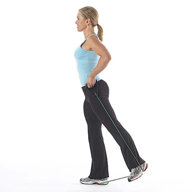 Woman performing resistance band exercise to tone glutes