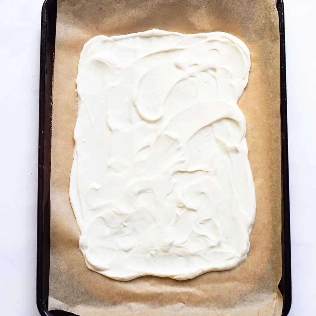 greek yogurt spread on parchment paper in baking sheet