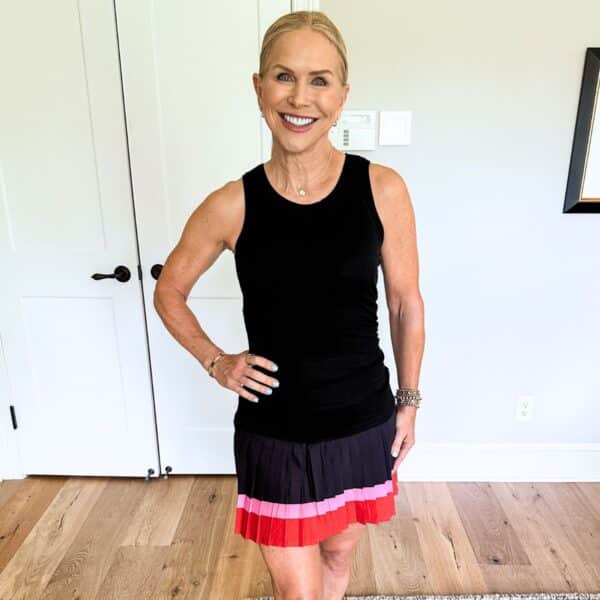 woman wearing best athletic skort for women over 50 in black pink and red