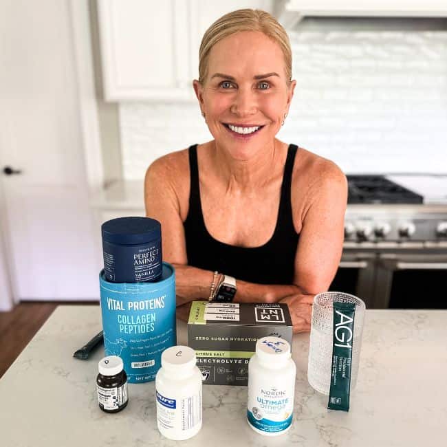 chris freytag smiling with various health supplements on counter.