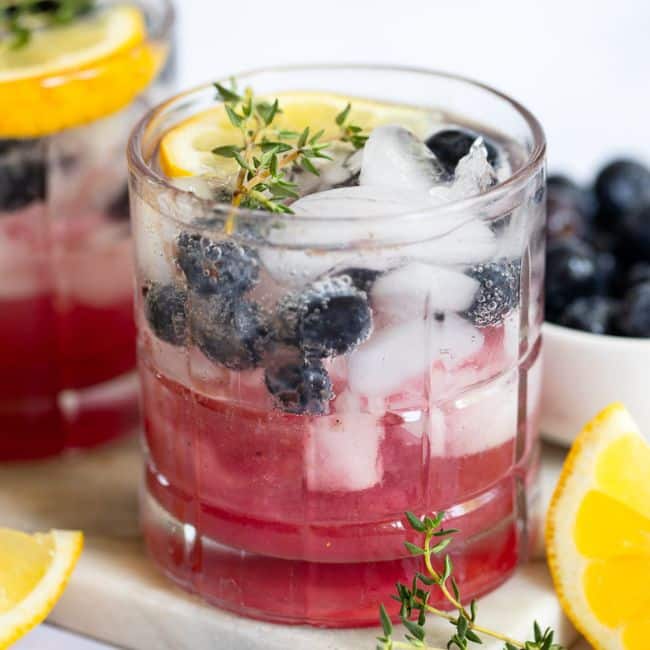 Blueberry Thyme Spritz mocktail recipe served in glass with garnish