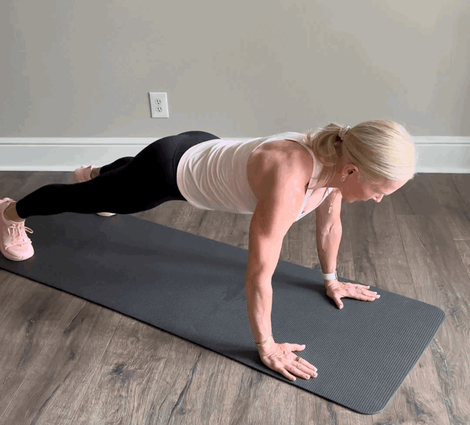 Person performing a plank exercise on a mat.