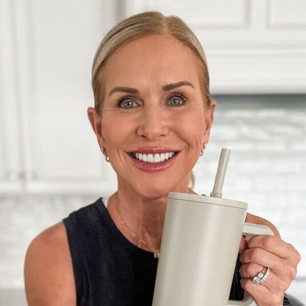 woman smiling holding clean water bottle free of harmful dirt and bacteria smiling