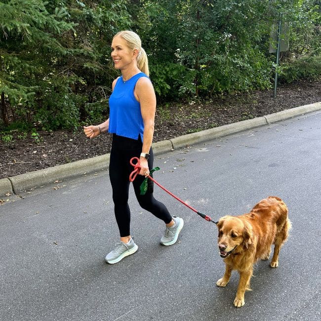 woman walking outdoors with golden retriever dog showing a dual task aging test for cognitive flexibility
