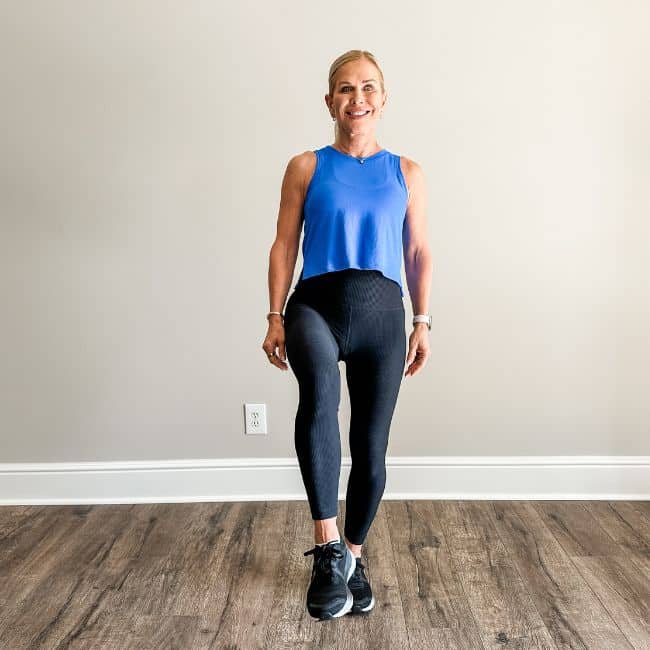 woman demonstrating one leg balance self aging test in workout clothing indoors