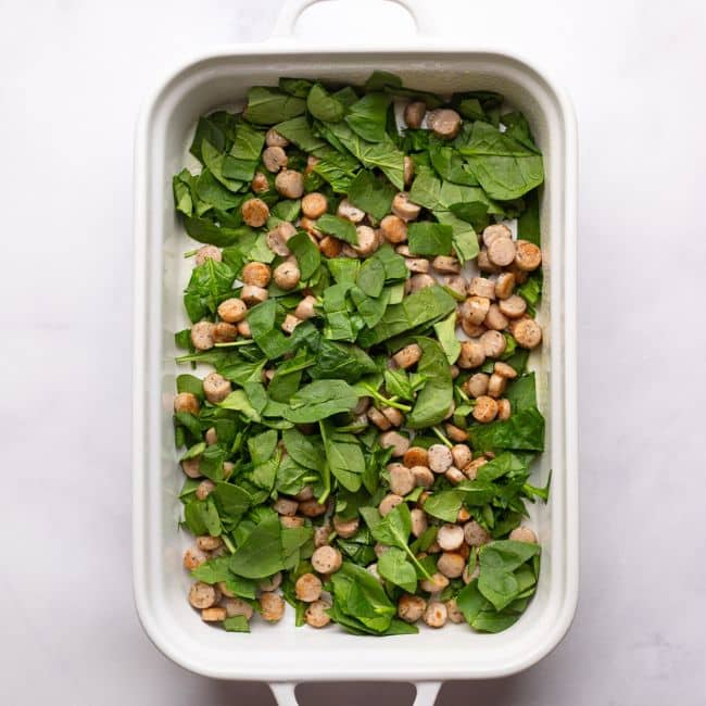 assembling sausage and spinach in pan for high protein egg bake