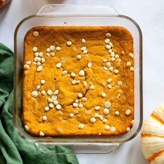 healthy pumpkin blondies baked in glass dish with white chocolate chips