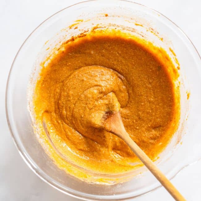 mixing pumpkin blondie ingredients together in glass bowl