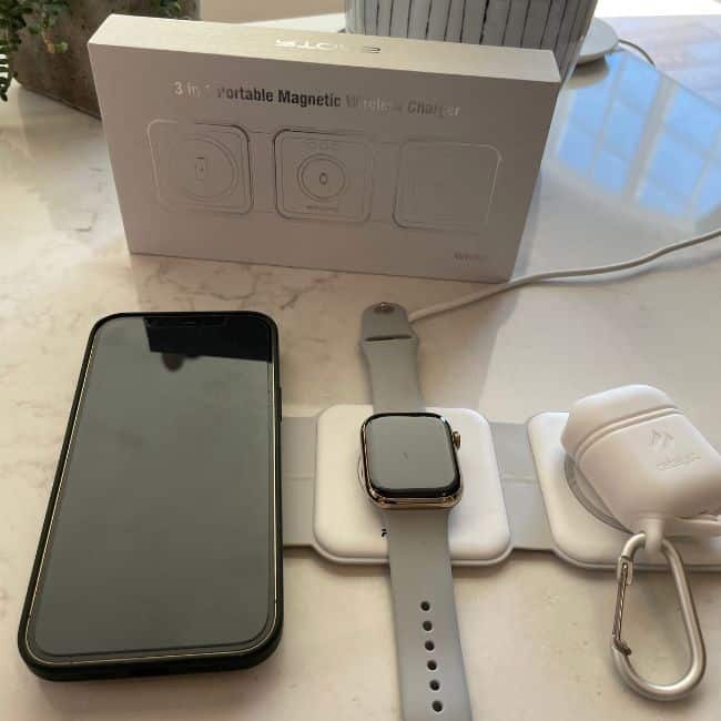 Three-in-one wireless charger on a hotel nightstand charging multiple devices