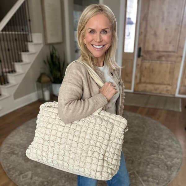 Chris Freytag holding a travel tote bag packed with organized travel essentials