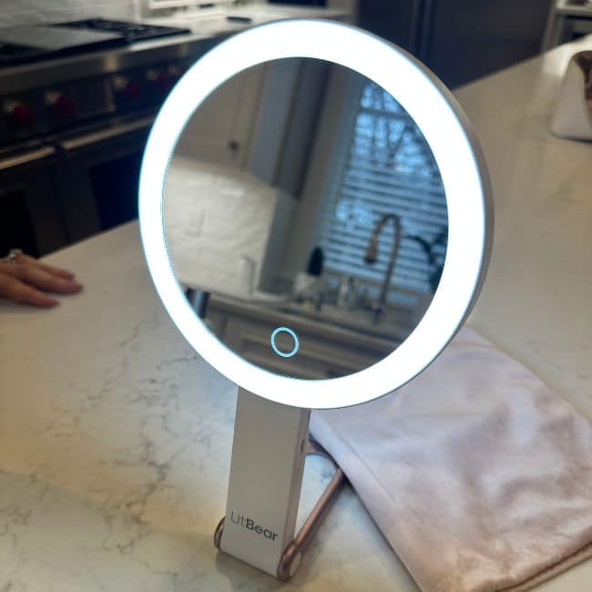 Lighted travel mirror with magnification on a hotel bathroom counter