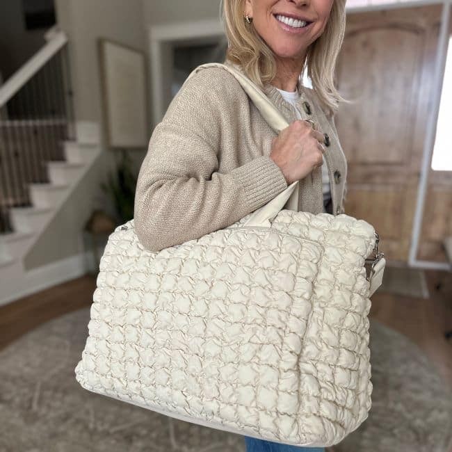 Carry-on tote bag filled with travel essentials including water bottle and electronics