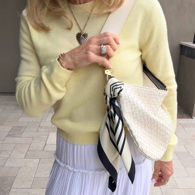 European-inspired accessories including silk scarf, crossbody bag, and simple jewelry styled for a Parisian look