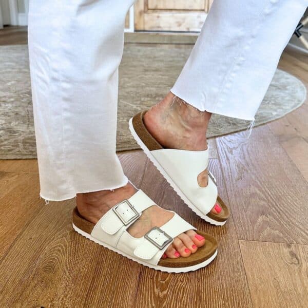 Woman over 50 wearing comfy not frumpy sandals with stylish casual summer outfit outdoors