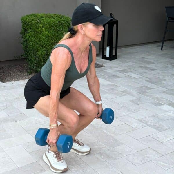 Woman over 50 doing strength training and stretching as part of a menopause workout plan focused on healthy aging and fitness during midlife.