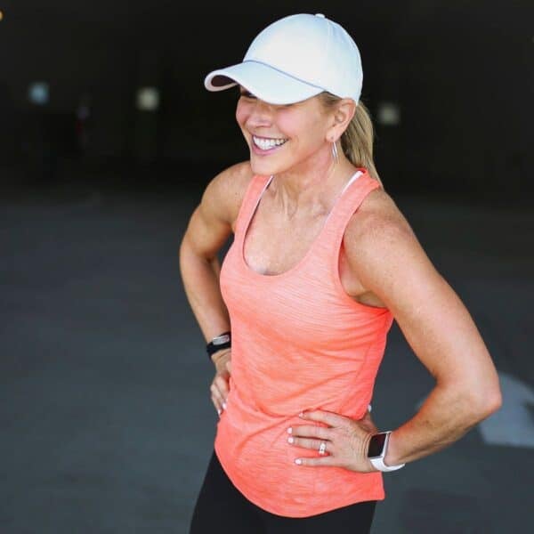 Woman over 50 walking outdoors in athletic wear to increase daily steps and support healthy aging