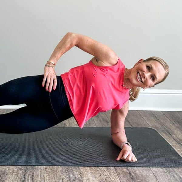 Woman performing bird dog core exercise on a yoga mat at home