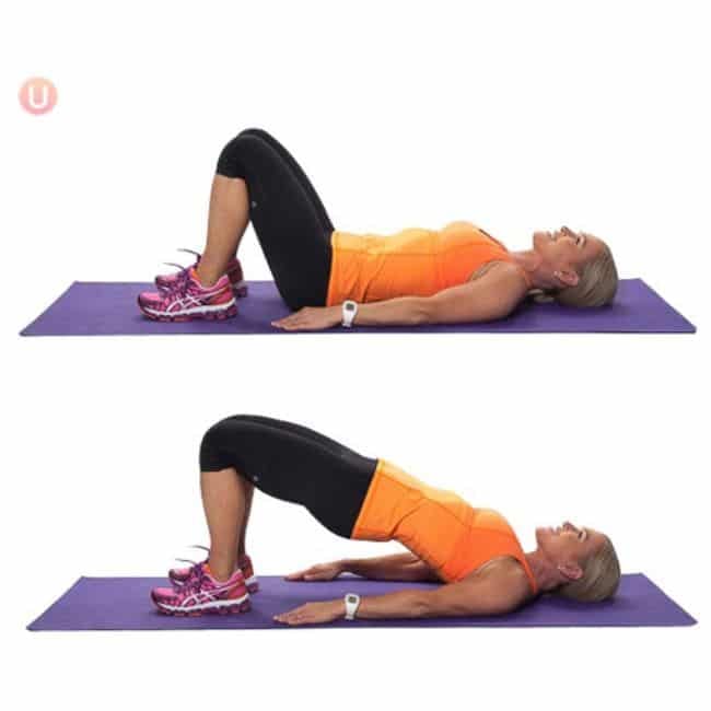 Woman lying on her back performing a glute bridge exercise on a yoga mat