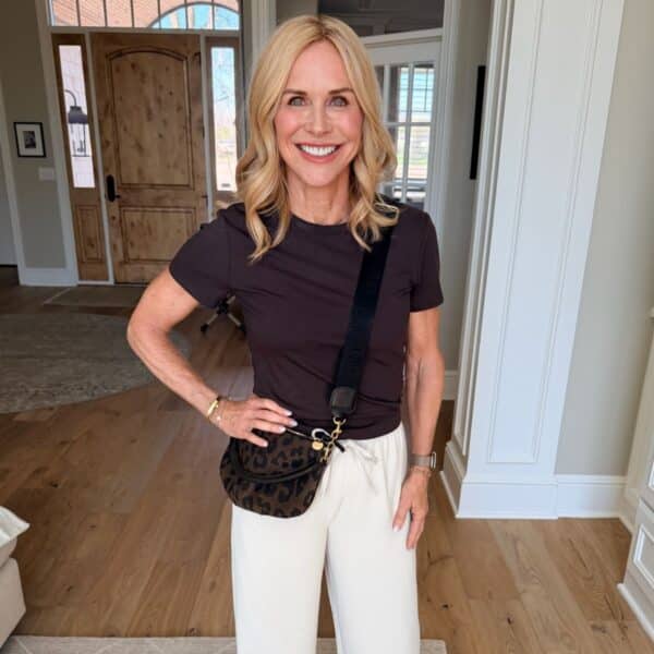 Woman over 50 wearing wide leg pants with a tucked-in fitted top and block heels, styled to flatter a midlife figure