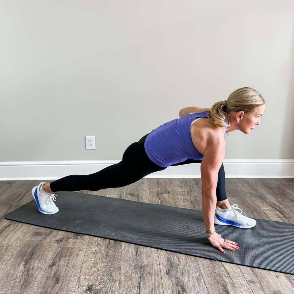 Woman in a low lunge with her back knee down and tailbone tucked, stretching tight hip flexors after walking
