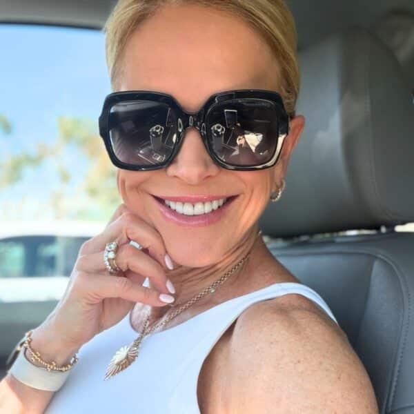 Chris Freytag smiling at her vanity with her favorite skincare and hair products for women over 50